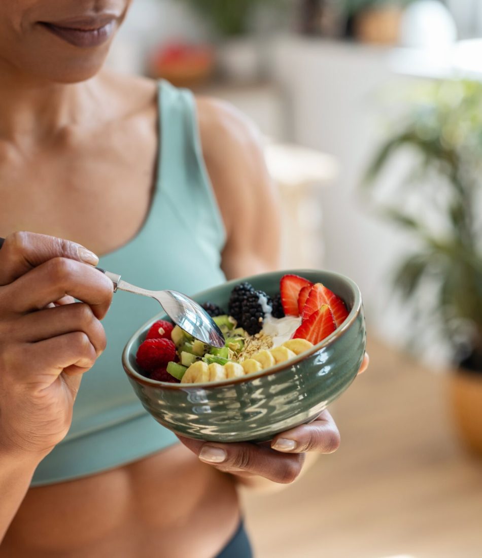 Close,Up,Of,Athletic,Woman,Eating,A,Healthy,Fruit,Bowl